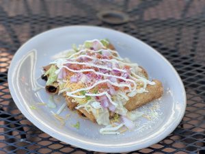 Mexican puff pastry stuffed with avocado and topped with cheese sauce